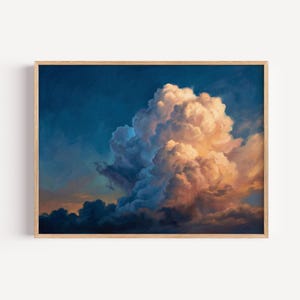 May include: A framed art print featuring a dramatic cloudscape. The artwork showcases a large, fluffy cloud formation in shades of white, peach, and blue against a deep blue sky. The wooden frame adds a natural touch to the artwork.
