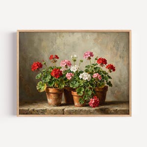 May include: A framed print of potted geraniums. The artwork features three terracotta pots filled with vibrant red, pink, and white geraniums. The flowers are in full bloom, with lush green foliage. The background is a muted, textured wall.