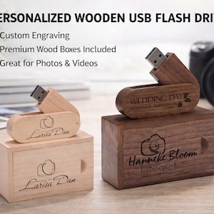 Puede incluir: Unidades flash USB de madera personalizadas con grabado. Una es de color claro con "Larisa Dan" y un logotipo de cámara, la otra es de color oscuro con "Wedding Day" y "Hanneke Bloom fotografie" grabados. Cajas de madera premium incluidas.