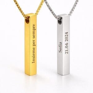 Pode incluir: Dois colares com pingente de barra vertical, um dourado e outro prateado, cada um em uma corrente de caixa correspondente. O pingente dourado está gravado com o texto Insieme per sempre. O pingente prateado traz o texto Sofia e 21.04.2024.