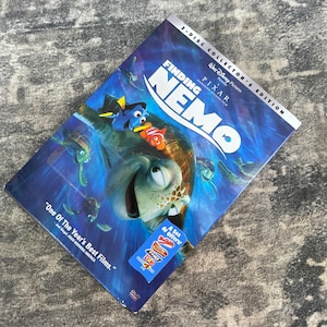 May include: A Finding Nemo 2-Disc Collector's Edition DVD case featuring a blue underwater scene with characters Marlin, Dory, and Crush. The cover includes the text Finding Nemo, Pixar, Walt Disney Pictures, and One Of The Year's Best Films.
