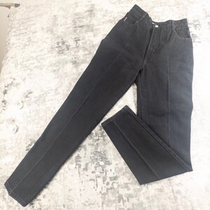 May include: A pair of black denim jeans. The jeans have a classic five-pocket design, a button and zipper closure, and a straight leg cut. The fabric appears to be a medium-weight denim, and the jeans are in good condition.