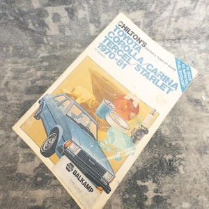 May include: A Chilton's repair and tune-up guide for Toyota Corolla, Carina, Tercel, and Starlet models from 1970-81. The white cover features a blue illustration of a car, engine parts, and the text 55 ways to improve fuel economy and NAPA Balkamp.
