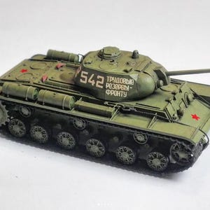 Op de afbeelding: Een gedetailleerd model van een militaire tank, geschilderd in olijfgroen. De tank heeft een lange kanonloop, een geschutskoepel en zichtbare rupsbanden. Het nummer "542" staat op de geschutskoepel, samen met tekst in een vreemde taal. Een rode ster is zichtbaar.