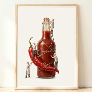 May include: A framed art print featuring a glass bottle filled with red hot sauce and a large red chili pepper. Four miniature figures dressed as chefs in white uniforms and hats are using ropes and a wooden ladder to secure the pepper to the bottle.
