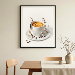 May include: A framed print depicts a whimsical scene of miniature chefs preparing coffee in an oversized white mug. The coffee is swirled, and coffee beans are scattered on the saucer. The print is displayed in a dining room setting.