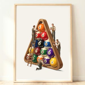 May include: A framed art print featuring a triangular wooden rack filled with colourful numbered billiard balls. Four miniature figures in vintage attire are positioned around the rack, interacting with the balls as if performing maintenance.
