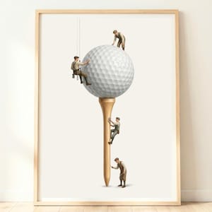 Puede incluir: Una lámina artística enmarcada que muestra una gran pelota de golf blanca sobre un tee de madera. Cuatro figuras en miniatura con ropa de trabajo de época limpian y mantienen la superficie de la pelota de golf y el tee.