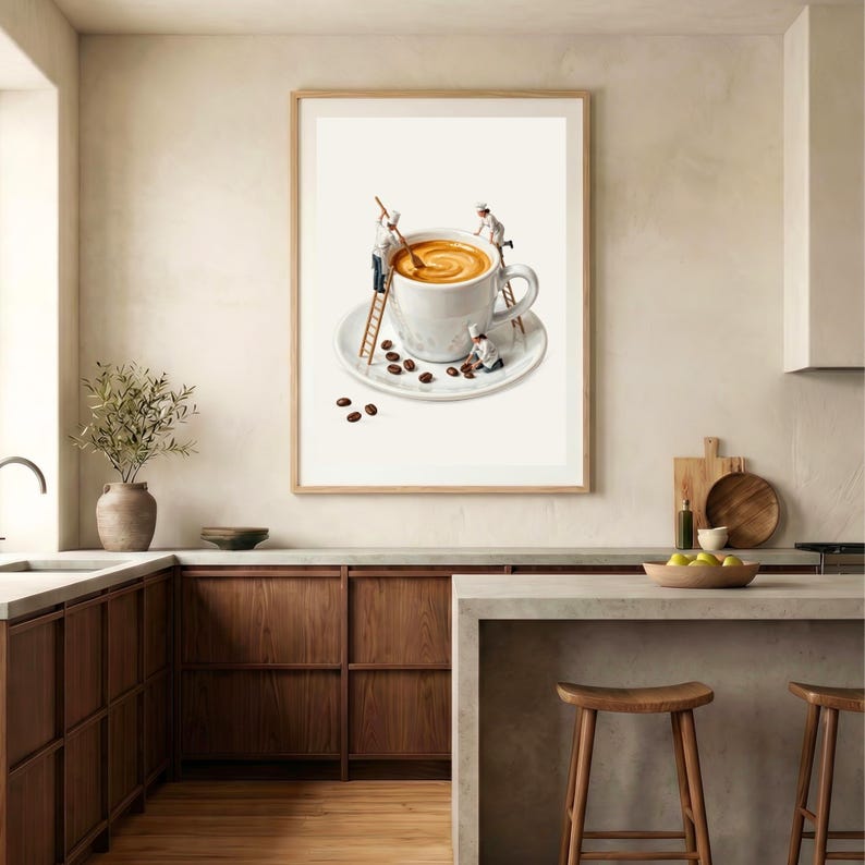 May include: A framed wall art print featuring a white ceramic coffee cup on a matching saucer. Three miniature figures in white chef uniforms are depicted interacting with the cup, using wooden ladders to stir the coffee and arrange beans.