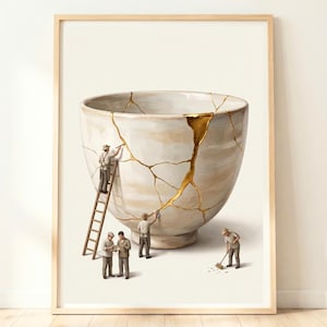 May include: Framed art print depicting a large, cracked ceramic bowl being repaired by miniature figures. The cracks are filled with gold, and the figures are dressed in work clothes. The artwork is set against a neutral background, with a wooden frame.
