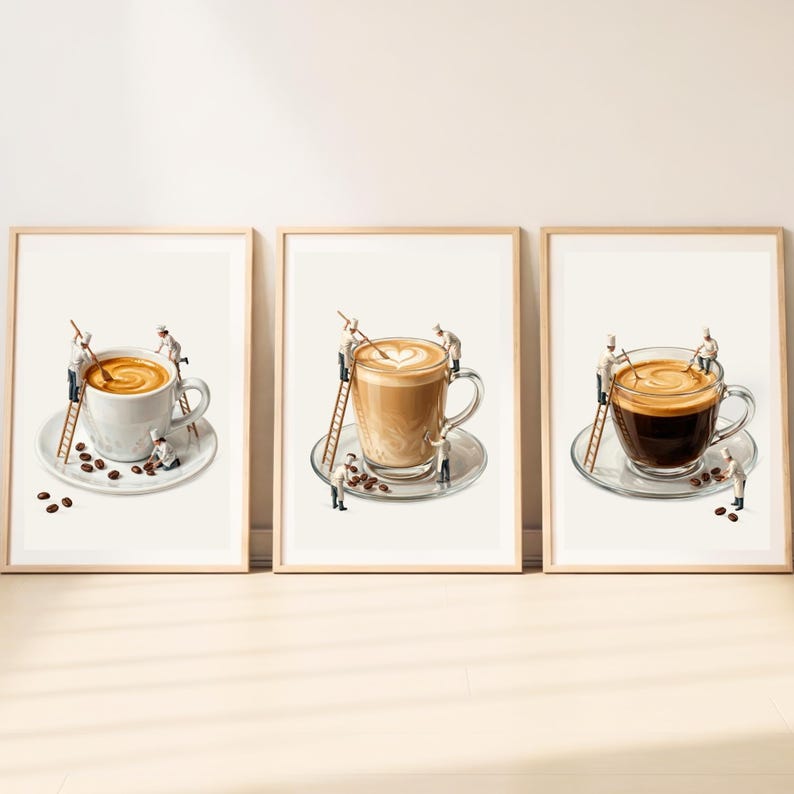 May include: A set of three framed wall art prints featuring miniature chefs working on coffee cups. Each print shows tiny figures on ladders stirring coffee or arranging coffee beans on saucers, with light-colored backgrounds and wooden frames.
