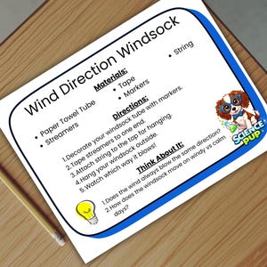 Pode incluir: Uma folha branca com uma borda azul, intitulada "Wind Direction Windsock", detalha um projeto científico com materiais e instruções. Um lápis está sobre uma superfície de madeira. Um filhote de desenho animado com óculos está no canto.