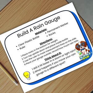 May include: A sheet with instructions for building a rain gauge, featuring a blue border and the title "Build A Rain Gauge." The materials listed include a clear plastic bottle and a ruler. A pencil rests on the wooden surface.