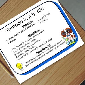 Może przedstawiać: Biała kartka z niebieską obwódką, zatytułowana "Tornado In A Bottle", zawiera materiały i instrukcje do eksperymentu naukowego. Ołówek leży na drewnianej powierzchni. Widoczne jest logo Science Pup.