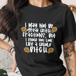 May include: Black t-shirt with the text "I May Not Be great with fractions, But I Know You Look Like a Whole Bitch" in white, accented with sunflower graphics. A casual, humorous tee.