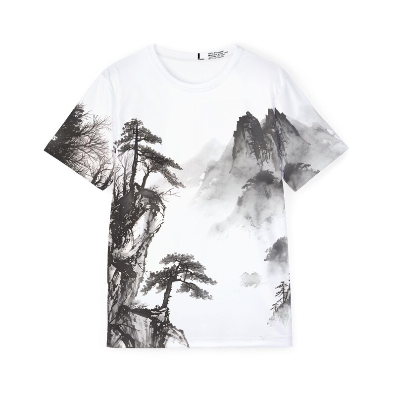 May include: A white short-sleeve t-shirt featuring a black and gray ink wash style landscape print. The design depicts jagged mountain peaks, pine trees, and rocky cliffs across the front. A size L label is visible at the inner neckline.