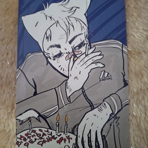 May include: Illustration of a person wearing a cat-eared hat and a gray Adidas tracksuit, crying. A birthday cake with lit candles and the words "Happy Birthday Dane" is in the foreground. The background is blue.
