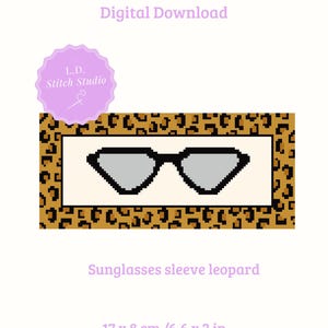 May include: Digital needlepoint stitch chart featuring a pixelated design of sunglasses. The sunglasses are set against a cream background, framed by a leopard print border. The chart measures 6.6 x 3 inches and is a digital download.