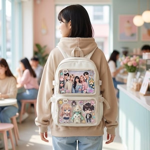 May include: A white backpack with two clear front pockets, each displaying colorful anime-style images. The top pocket features a group of people, while the bottom pocket showcases anime characters. The backpack has adjustable straps and a top handle.