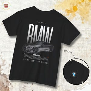May include: Black t-shirt featuring a silver BMW M4 G82 car graphic. The design includes the BMW logo, car specifications, and the text "BMW M4 G82". A smaller image of the BMW logo is on the front side of the shirt.