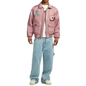 May include: A dusty rose bomber jacket with patches and a zipper closure. The jacket is paired with light blue, baggy jeans. The model is wearing a white t-shirt and white sneakers.