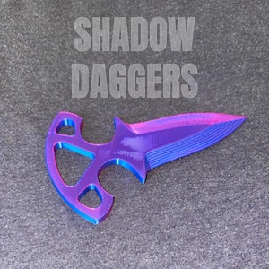 Puede incluir: Una daga impresa en 3D con un degradado de azul, morado y rosa. El mango presenta un diseño abierto único. El texto "SHADOW DAGGERS" se muestra encima de la daga.