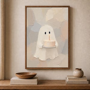 Peut inclure: Une impression d'art encadrée représentant un personnage fantôme blanc tenant un petit gâteau avec une seule bougie allumée. L'œuvre utilise un style empâtement texturé avec une palette de couleurs neutres de beige doux, crème et gris.