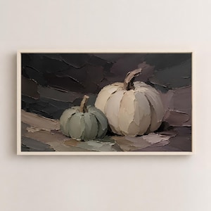 Può includere: Un dipinto a olio raffigurante due zucche realizzate con pennellate spesse e visibili. Una zucca più piccola color verde salvia è posizionata accanto a una zucca più grande color crema su uno sfondo scuro dai toni antracite e marrone.
