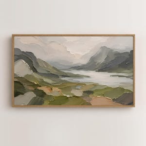 May include: A rectangular landscape painting in a wooden frame featuring thick, textured impasto brushstrokes. The scene depicts rolling hills in shades of olive green, sage, and brown, leading toward a central body of water under a cloudy sky.