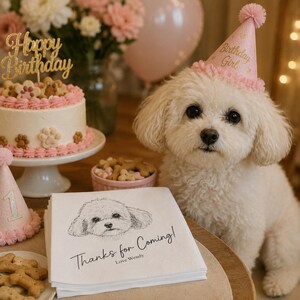 Könnte beinhalten: Ein weißer Hund mit einem rosa Partyhut mit der Aufschrift Birthday Girl, neben einem Stapel weißer Servietten mit einer Hundeskizze und dem Text Thanks for Coming! Love Wendy, einem Kuchen mit Pfotenabdrücken und einer Schale mit Leckerlis.