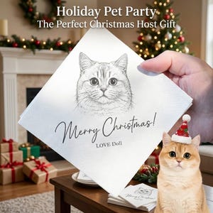 Könnte beinhalten: Eine weiße Papierserviette mit einer schwarzen Strichzeichnung eines Katzengesichts sowie dem Text "Merry Christmas!" und "LOVE Doll" in schwarzer Schrift. Eine kleine Katze mit einer roten und weißen Weihnachtsmütze ist vorne zu sehen.