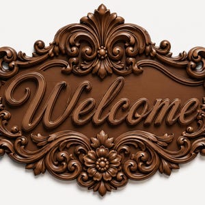May include: A brown, oval-shaped wall plaque featuring the word Welcome in raised, cursive lettering. The plaque is decorated with intricate, symmetrical carved scrollwork, floral motifs, and leaf patterns surrounding the central text.
