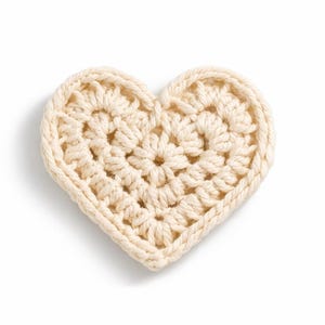 May include: A cream-colored, crocheted heart-shaped item. The heart is made with a textured stitch pattern, and the edges are neatly defined. The item is likely handmade and sits on a white background, suggesting a craft or decorative item.