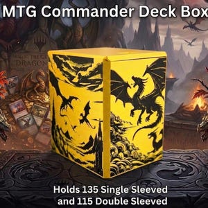 Peut inclure: Boîte de deck MTG Commander jaune avec des silhouettes de dragons noirs. La boîte peut contenir 135 cartes à manchons simples ou 115 à manchons doubles. Le texte "MTG Commander Deck Box" est visible.