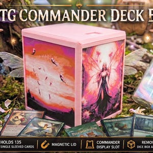 May include: A light pink MTG Commander deck box featuring a fairy illustration on the front and a sunset scene with flying creatures on the side. The box includes a magnetic lid, a display slot, and holds 135 single sleeved cards.