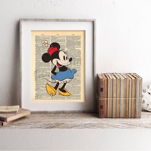 May include: Framed print featuring a vintage illustration of Minnie Mouse. Minnie is depicted in a blue dress, yellow shoes, and a red bow. The artwork is set against a backdrop of aged book pages, displayed on a wooden shelf with books and a clock.
