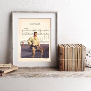 May include: Framed print featuring a Star Wars image with the text "Binary Sunset" above a musical score. The print is displayed on a rustic wooden shelf with a stack of books, a clock, and other decorative items.