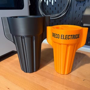 May include: Two plastic wire connector tools with a fluted, tapered design and side wings. One tool is matte black, and the other is bright orange with the black text GRECO ELECTRICAL printed clearly on the front side of the orange unit.