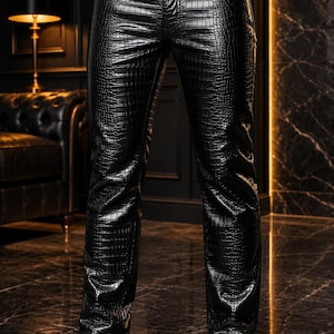 Puede incluir: Pantalones negros con una textura brillante en relieve de piel de cocodrilo. Estos pantalones tienen una cintura estándar con cierre de botón, trabillas para cinturón y un diseño clásico de cinco bolsillos. El material tiene un acabado reflectante.