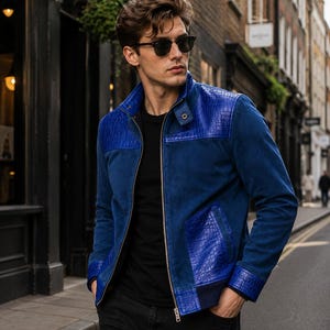 May include: A vibrant blue jacket featuring a stand-up collar, a full-length silver zipper, and contrasting textured panels with a crocodile-skin pattern on the shoulders, cuffs, and pockets, worn over a plain black t-shirt and black pants.
