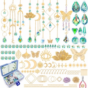 May include: A DIY suncatcher kit featuring gold-toned metal charms including butterflies, lotus flowers, moons, suns, and eyes, paired with iridescent crystal prisms, chains, jump rings, and a pair of pliers in a plastic storage container.