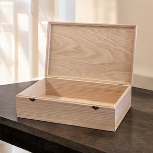 May include: A light wood box with a hinged lid and two metal clasps. The box is open and empty.