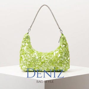 May include: A lime green sequined handbag with a silver chain strap. The bag has a crescent shape and is covered in small, reflective sequins. The text "DENIZ BAG STYLE" is printed at the bottom of the image.