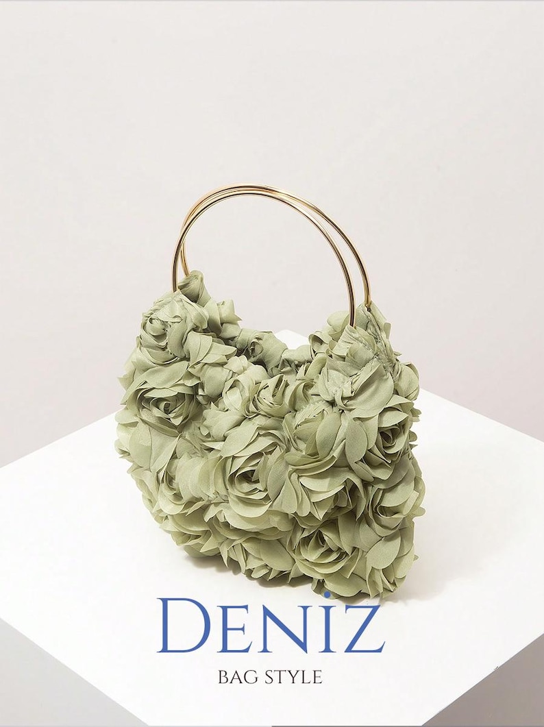 May include: A sage green handbag with a floral design. The bag is covered in fabric roses and has gold-coloured handles. The text "DENIZ BAG STYLE" is printed in blue on the white surface.