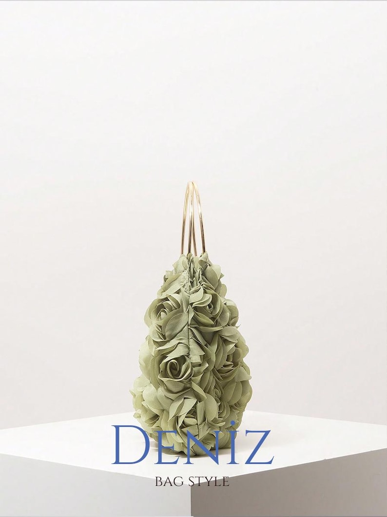 May include: A light green handbag with a floral design. The bag is covered in fabric roses and has gold-coloured handles. The text "DENIZ BAG STYLE" is printed on the front of the bag.