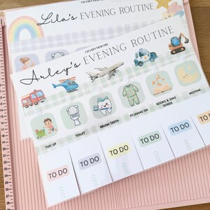May include: A paper evening routine checklist for children titled Arley's Evening Routine, featuring illustrations of a fire truck, helicopter, airplane, police car, and excavator, with sliding tabs labeled TO DO for tasks like tidy up, toilet, brush teeth, and bedtime.
