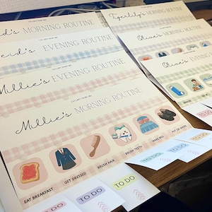 May include: A set of personalized routine charts featuring names like Millie, Reid, Olive, and Tigerlily. Each chart includes a morning or evening routine header, a Lullaby Printing logo, and a row of icons with labels such as Eat Breakfast, Get Dressed, Brush Hair, Brush Teeth, Make Bed, and Put On Shoes, accompanied by movable To Do tabs.