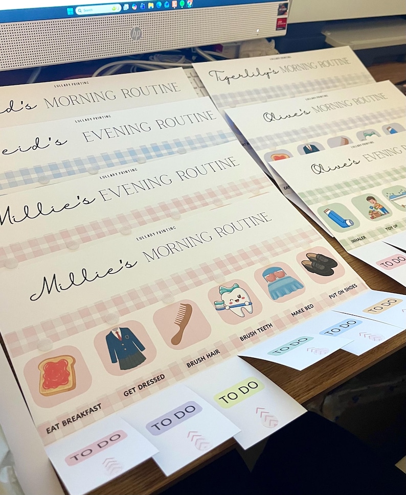 May include: A set of personalized routine charts featuring names like Millie, Reid, Olive, and Tigerlily. Each chart includes a morning or evening routine header, a Lullaby Printing logo, and a row of icons with labels such as Eat Breakfast, Get Dressed, Brush Hair, Brush Teeth, Make Bed, and Put On Shoes, accompanied by movable To Do tabs.