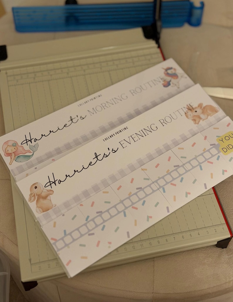 May include: Two rectangular paper charts titled Harriet's Morning Routine and Harriet's Evening Routine. The charts feature illustrations of a unicorn, a mermaid, and a rabbit, with a grid for tracking tasks and colorful confetti-like accents.