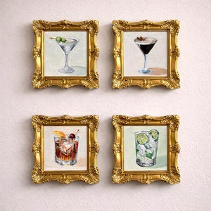 Könnte beinhalten: Vier gerahmte Aquarelldrucke von Cocktails. Jeder Druck befindet sich in einem goldenen, verzierten Rahmen. Die Cocktails umfassen einen Martini mit Oliven, einen Espresso Martini, einen Old Fashioned und einen Mojito.
